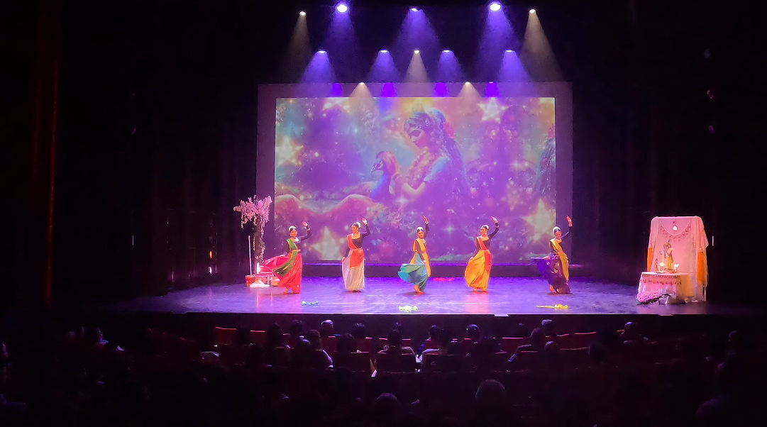 Dansers voor projectie van Radha en Krishna